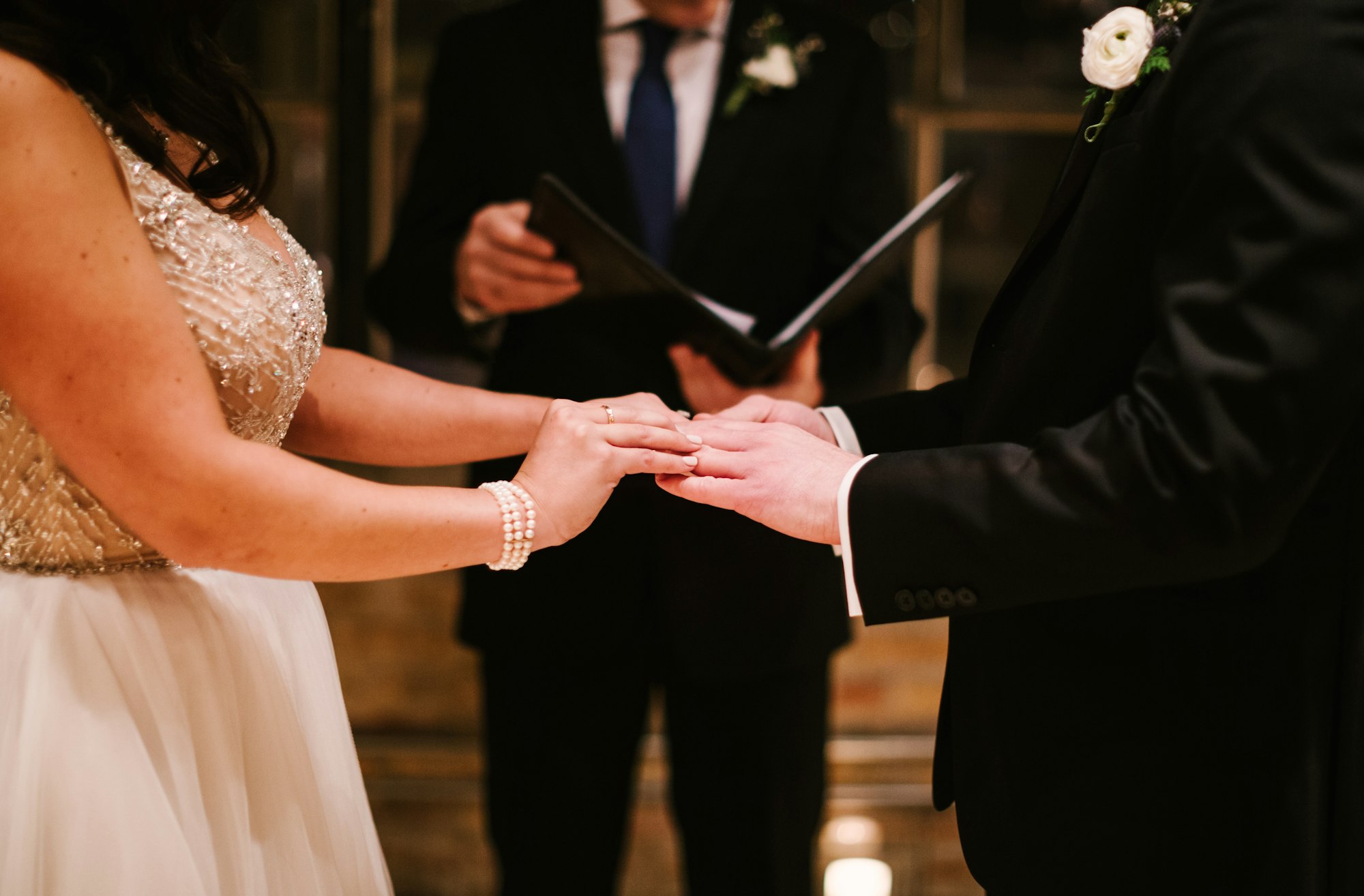 couple at their wedding ceremony, standing at the altar, exchanging rings